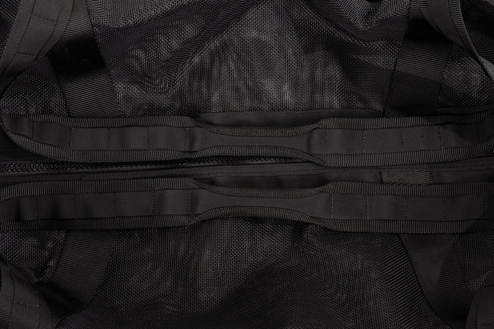 Close-up of a black gear bag showing mesh fabric, woven webbing straps, and a central zipper pocket detail.
