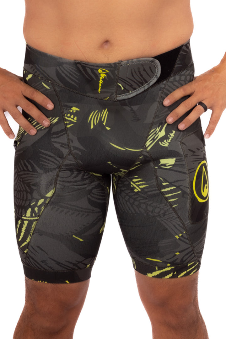 Male model wearing Waihana Lime Fishbone Tech Jammers wetsuit shorts in a dark grey and lime yellow fishbone camo pattern, shown from waist to mid-thigh against a white background.