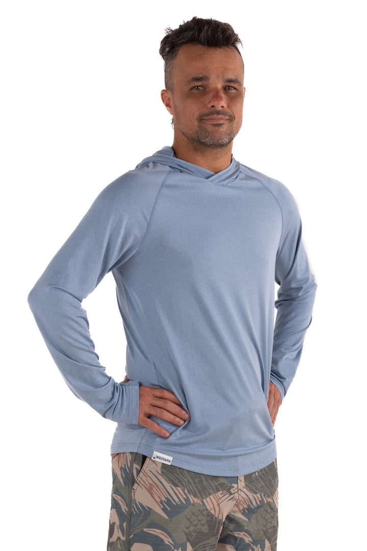 Male model wearing the Waihana Mariner Blue Hooded Long Sleeve sun shirt in a light steel blue color, shown from a slight angle against a white studio background.