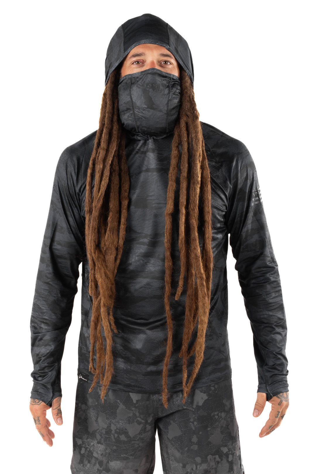Male model with long dreadlocks wearing the Waihana Tropicam Black Sun Shirt with built-in hood and face gaiter, shown from the front against a white studio background.